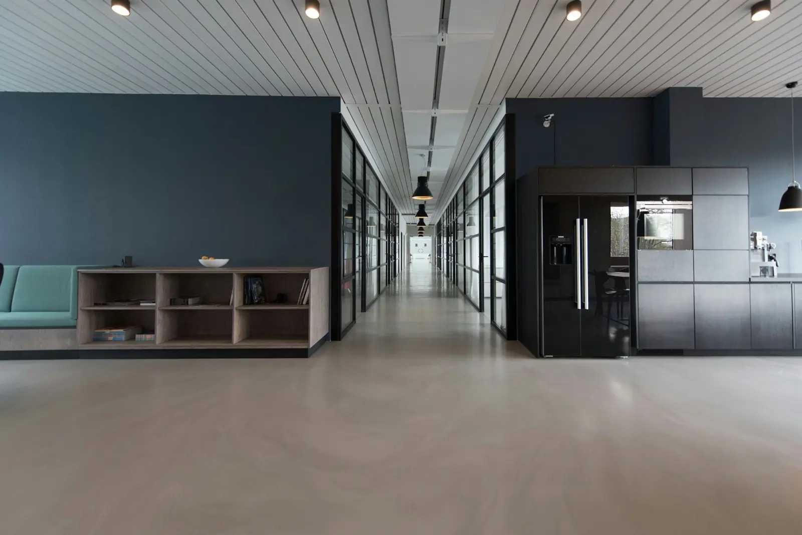 A quiet conference room with a long wooden table prepared for a working session